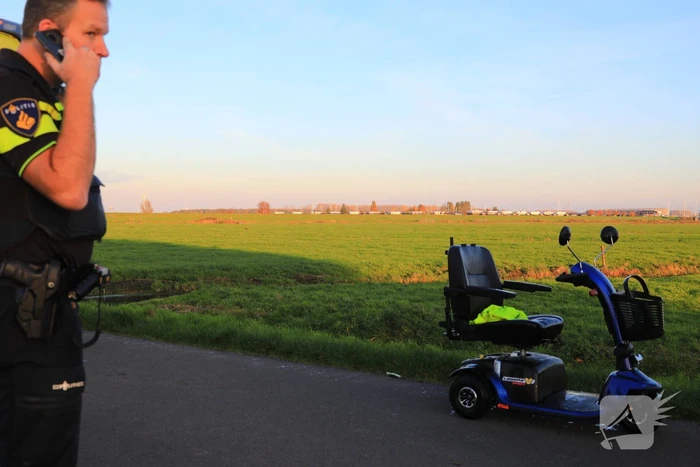Man met scootmobiel te water