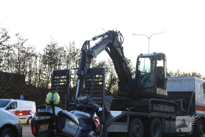 Vrachtwagen met graafmachine ramt spoorbrug