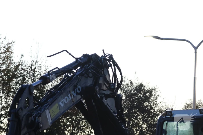 Vrachtwagen met graafmachine ramt spoorbrug