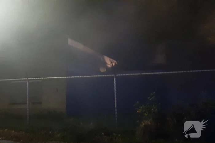 Berg afval in brand achter schoolgebouw