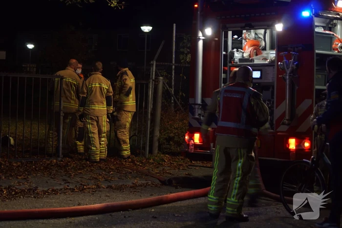 Berg afval in brand achter schoolgebouw