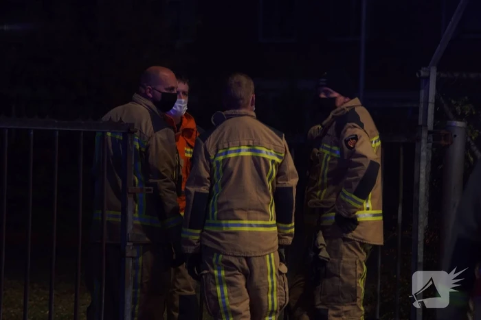 Berg afval in brand achter schoolgebouw