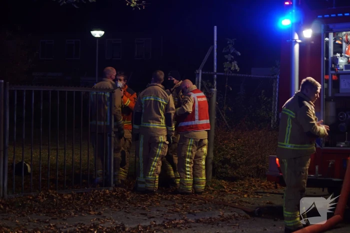 Berg afval in brand achter schoolgebouw