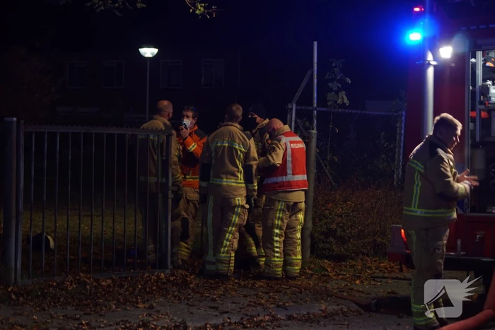 Berg afval in brand achter schoolgebouw