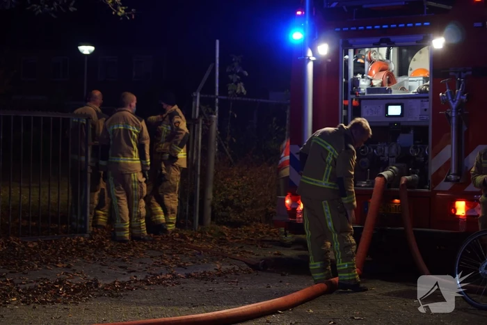 Berg afval in brand achter schoolgebouw