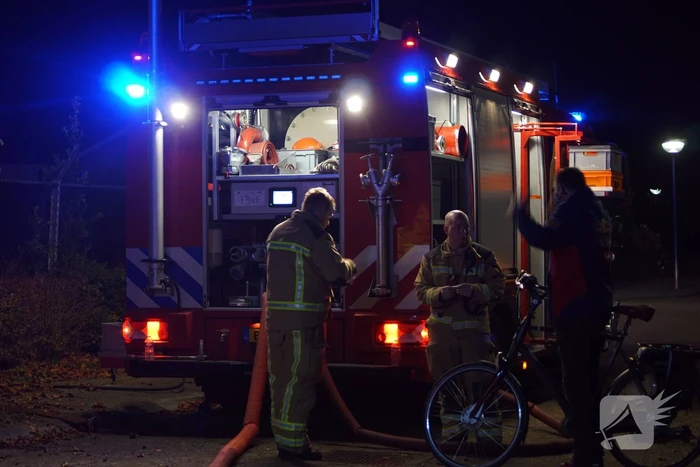 Berg afval in brand achter schoolgebouw