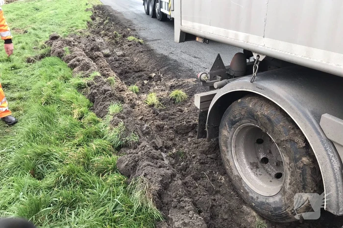 Vrachtwagen rijdt zich vast in berm langs snelweg