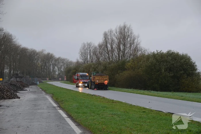 Tractor met lading zand vat vlam