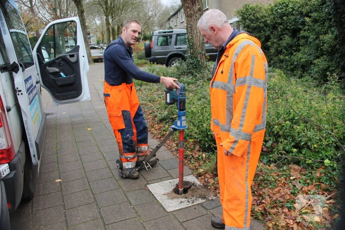 Straat opengebroken door gesprongen waterleiding in Smitsveen