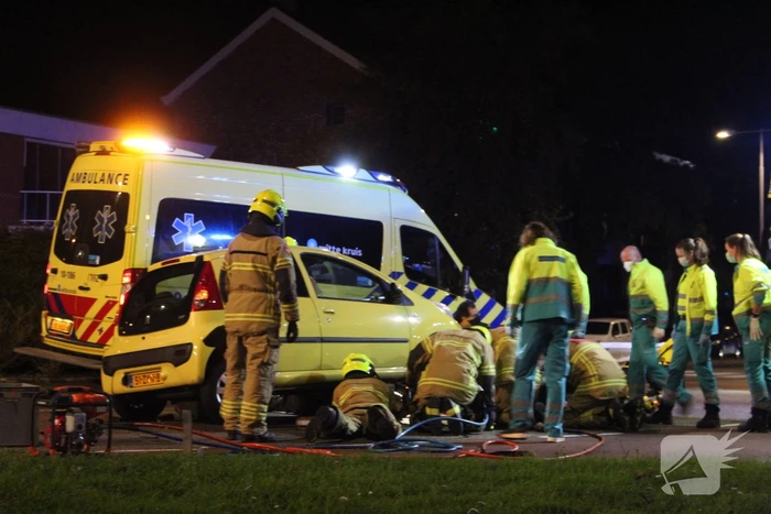 Fietser bekneld onder auto