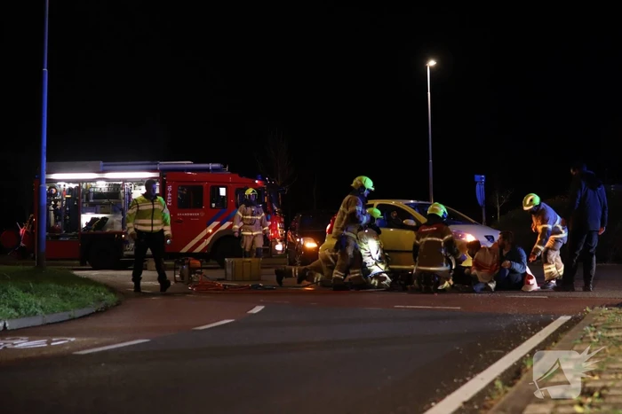 Fietser bekneld onder auto