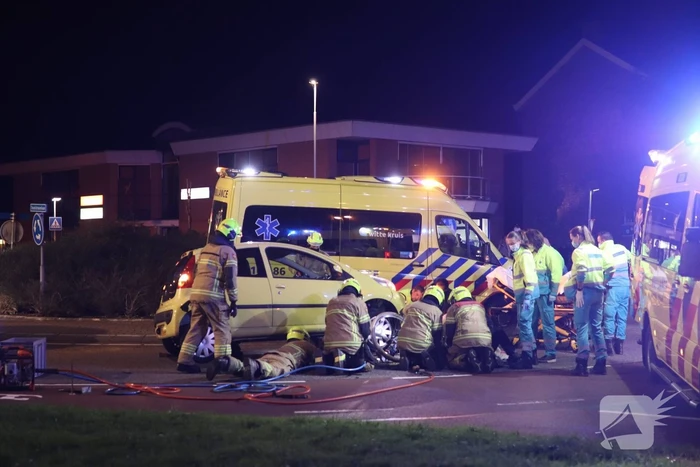 Fietser bekneld onder auto