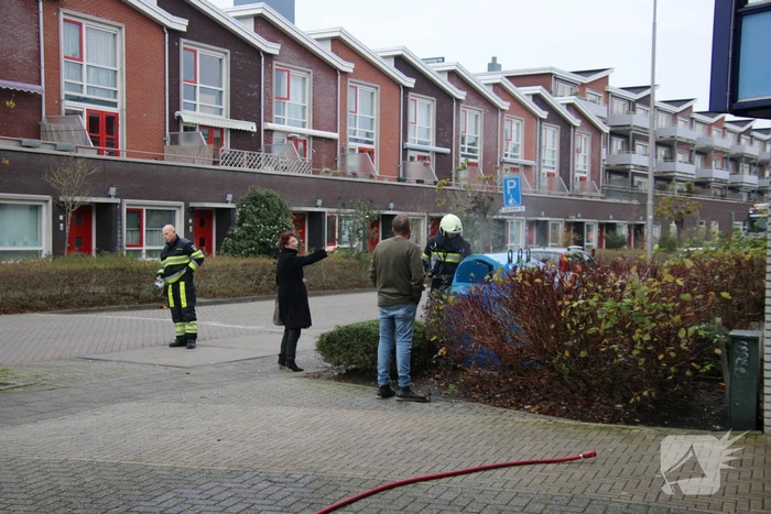 Omstanders blussen brand in papiercontainer