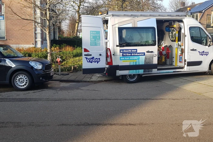 Straat opengebroken door gesprongen waterleiding