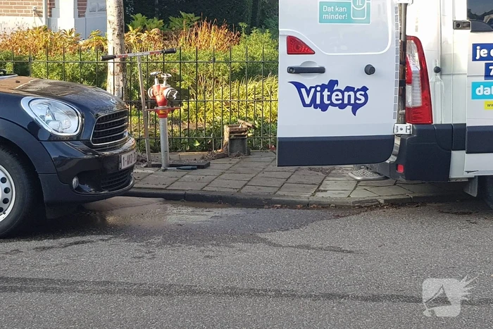 Straat opengebroken door gesprongen waterleiding