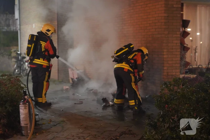Oud papier tegen woning in brand gestoken