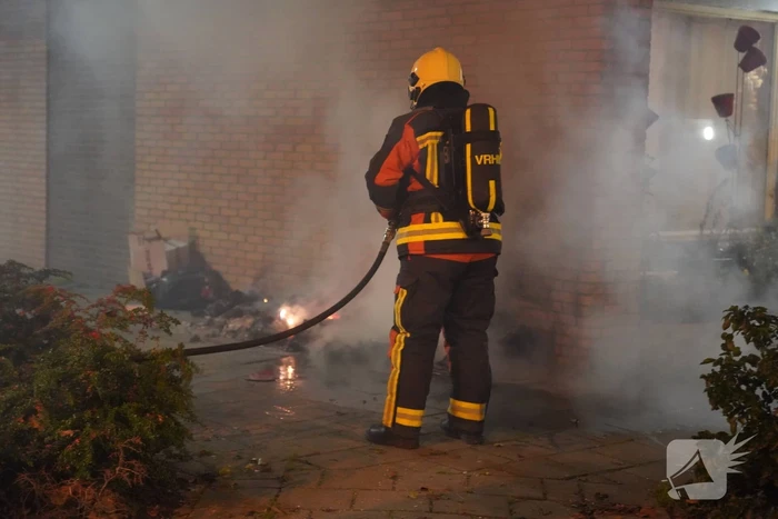 Oud papier tegen woning in brand gestoken
