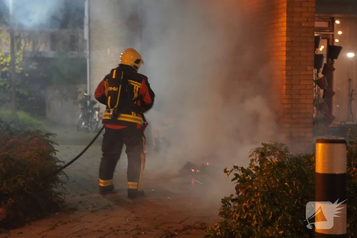 Oud papier tegen woning in brand gestoken
