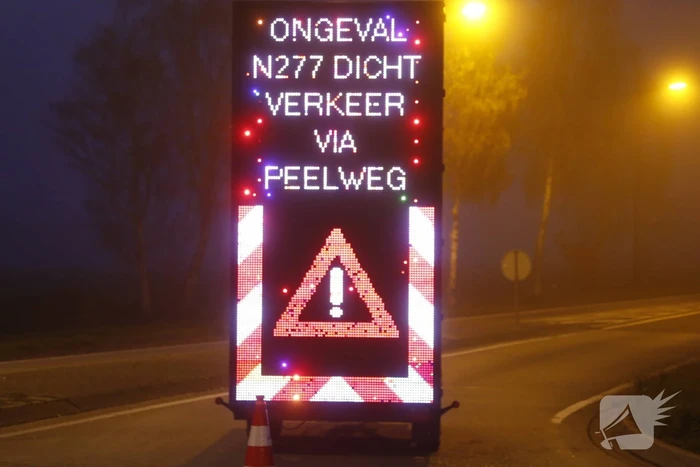 Vrachtwagen met aanhanger met hooi ramt boom