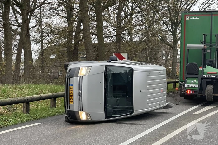 Bestelbus belandt op zijn kant via vangrail