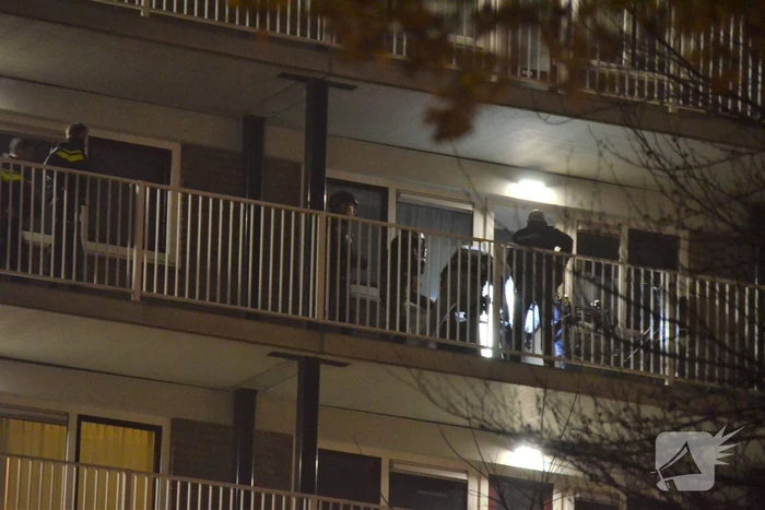 Verward persoon op galerij van flatwoning