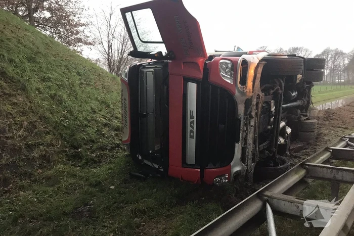 Vrachtwagen belandt op zijn kant in de berm