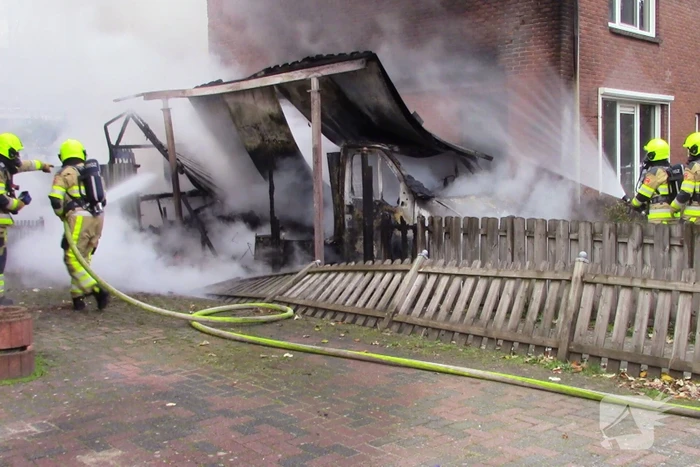 Camper naast woning gaat in vlammen op