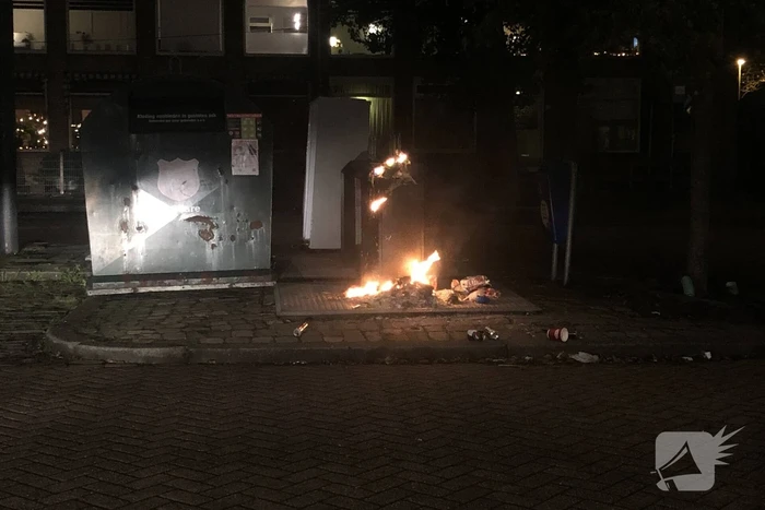 Papier in brand naast container