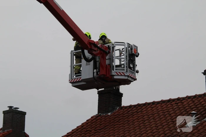 Brandweer blust brand in schoorsteen
