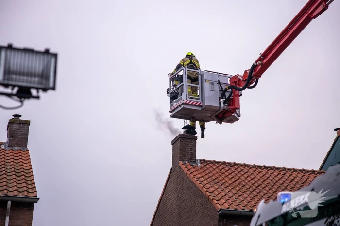 Brandweer blust brand in schoorsteen