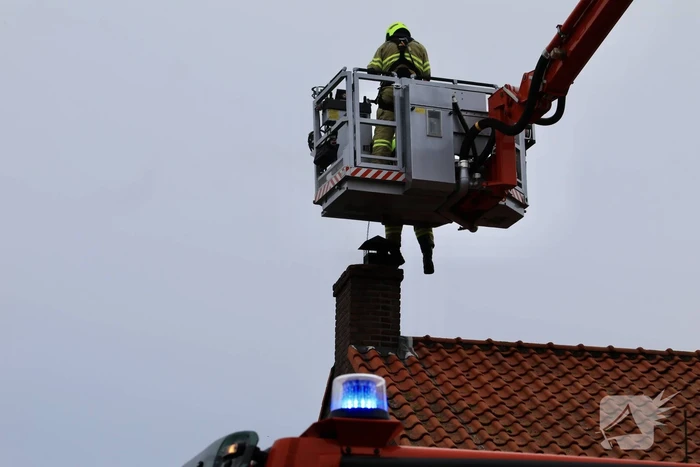 Brandweer blust brand in schoorsteen