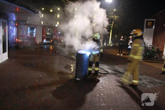Brandweer blust twee brandende prullenbakken
