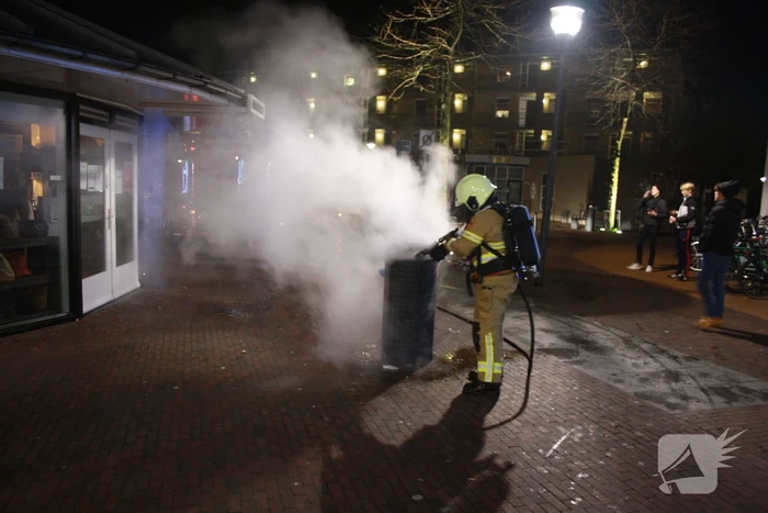 Brandweer blust twee brandende prullenbakken