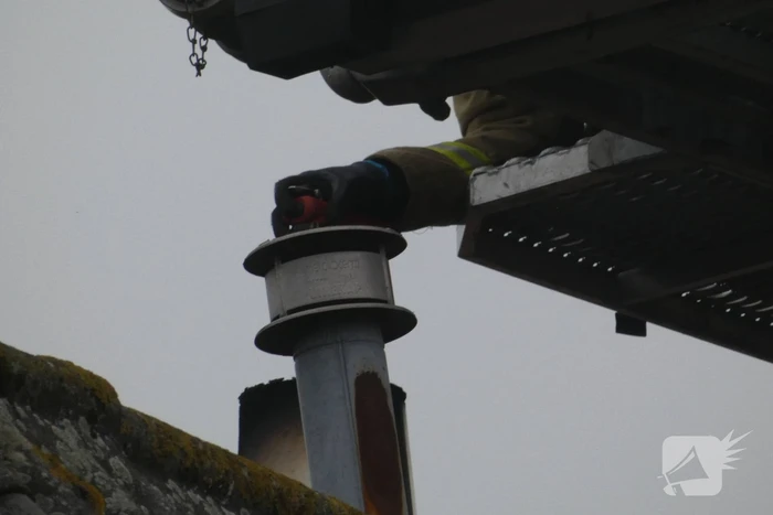 Brandweer blust brand in schoorsteen