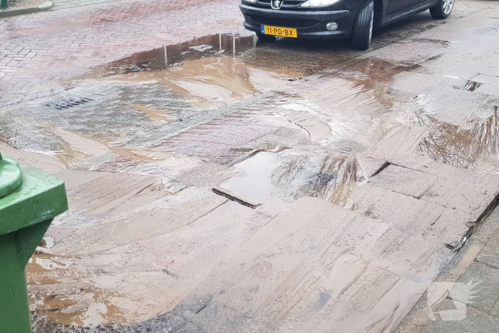 Leidingbreuk zorgt voor zand en water over de weg