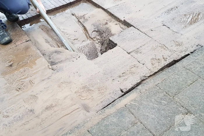 Leidingbreuk zorgt voor zand en water over de weg