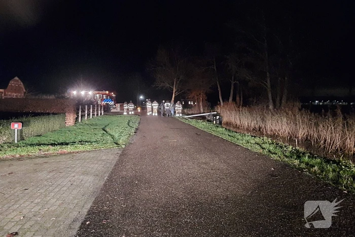 Auto vliegt uit de bocht en belandt op zijn kant in sloot