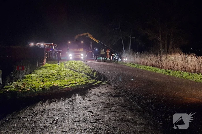 Auto vliegt uit de bocht en belandt op zijn kant in sloot