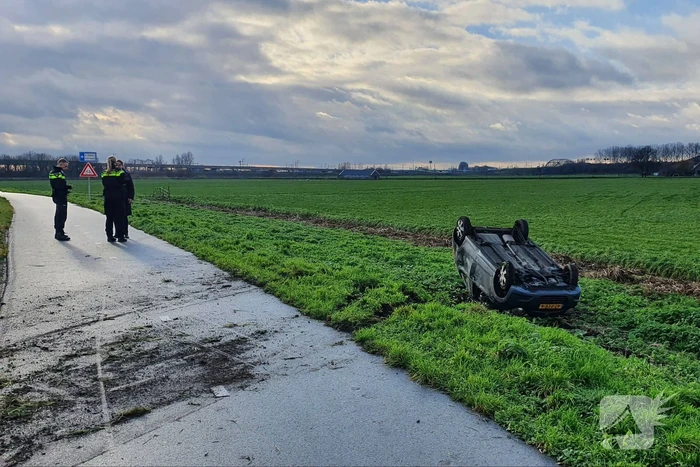 Personenauto raakt van de weg en belandt op zijn dak