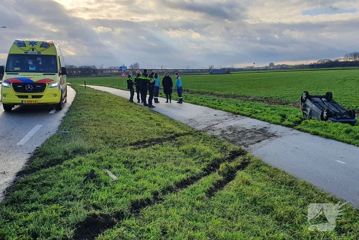 Personenauto raakt van de weg en belandt op zijn dak