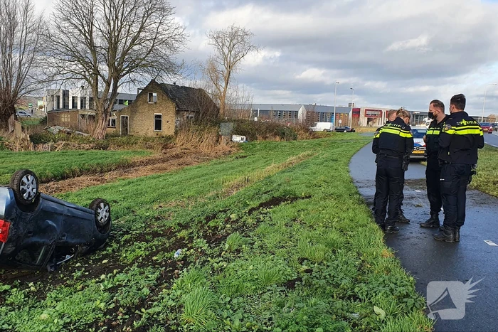 Personenauto raakt van de weg en belandt op zijn dak