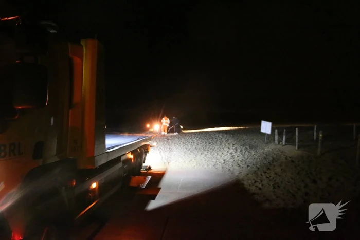 Automobilist rijdt auto vast op strand