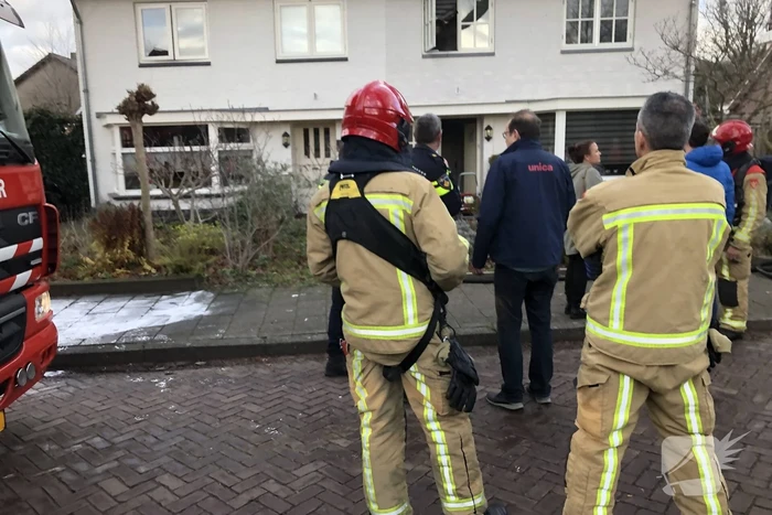 Zwarte rookwolken uit woning