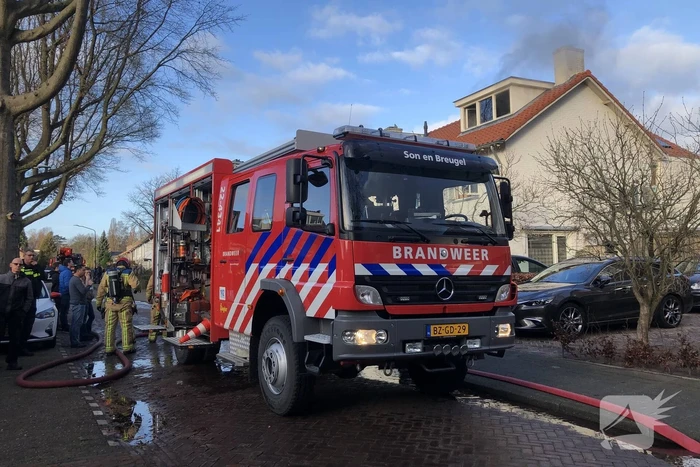 Zwarte rookwolken uit woning