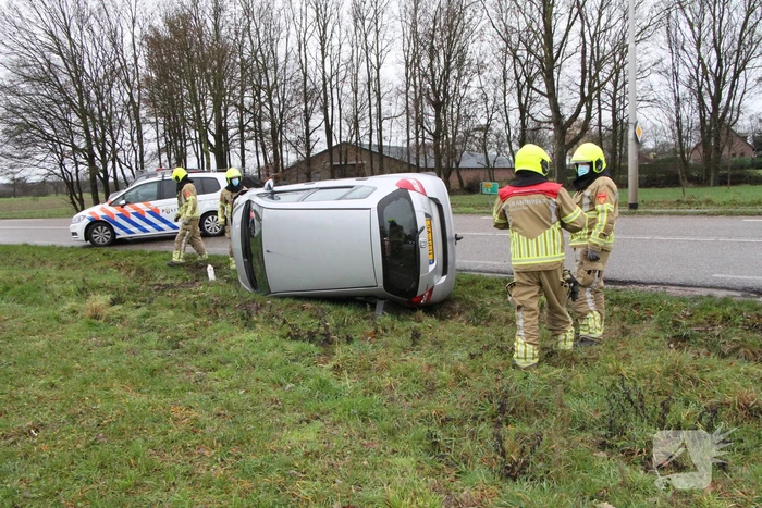 Auto belandt op zijn kant in berm