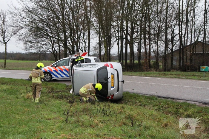 Auto belandt op zijn kant in berm