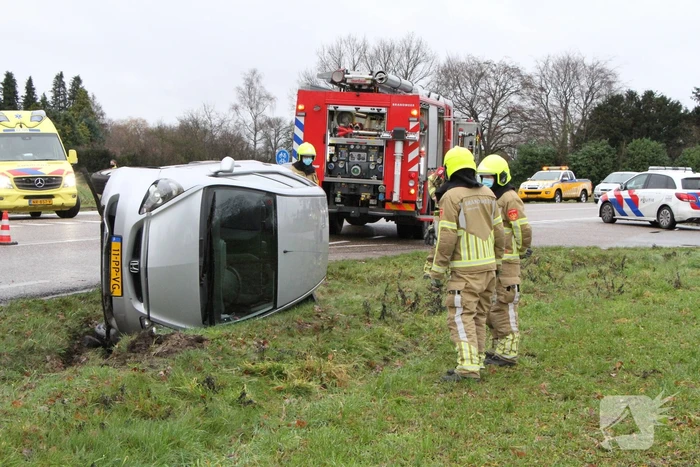 Auto belandt op zijn kant in berm