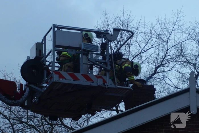 Brandweer veegt schoorsteen na brand