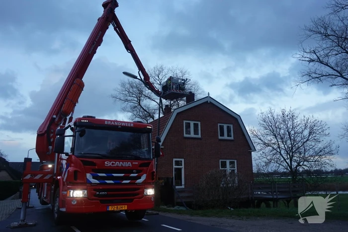 Brandweer veegt schoorsteen na brand