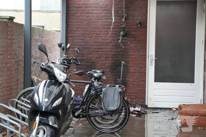 Brand onder overkapping van woning